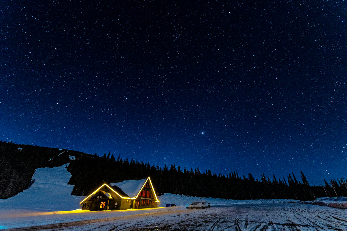 Snowy chalet under a starry night sky in the mountains (photo: Rodney Saigeon, Unsplash)